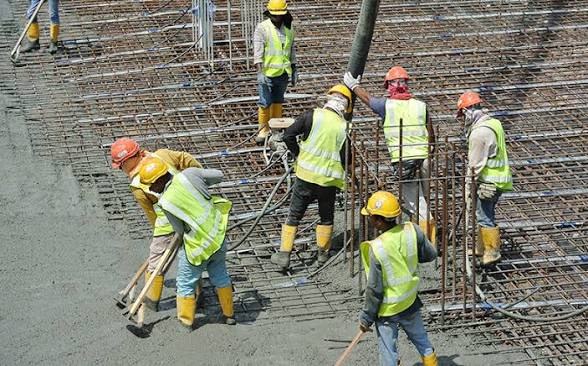 Equipe executando concretagem de laje sobre armação montada